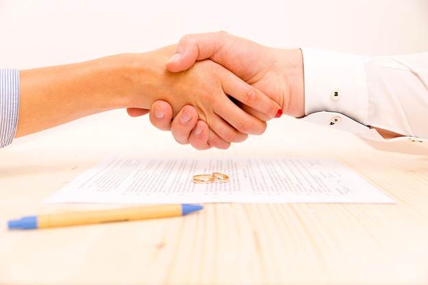signing agreement at table couple